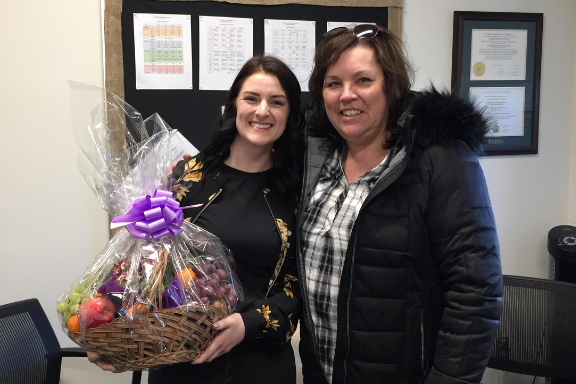 Teacher Ariana Sterling and Trustee Jackie Comeau with gift basket