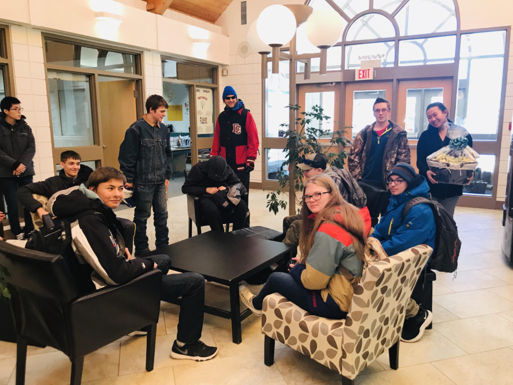 In the school foyer with some of her students, Michelle Tran (far right) holds the gift basket she received from the school board